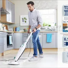 Mężczyzna sprząta kuchnię mopem parowym.